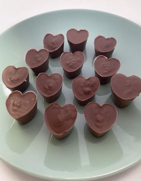 Schoko-Pralinen in Herzform auf einem weißen Teller