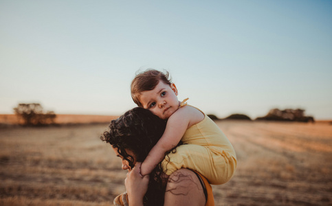 sad baby on moms shoulders